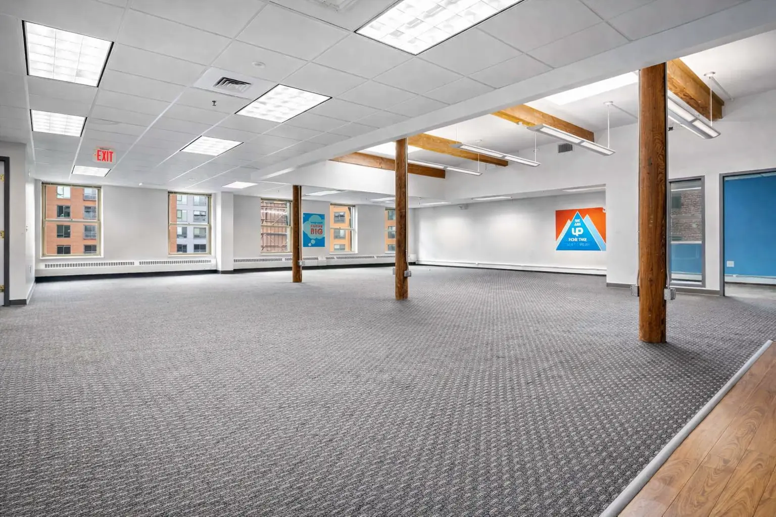 Large open office floor with exposed wooden columns and flexible workspace layout