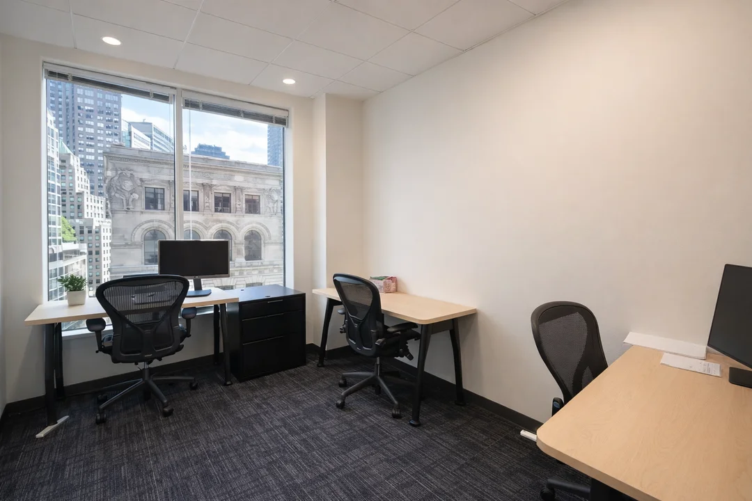 Private office with dedicated desks, ergonomic chairs, and city view window in modern workspace