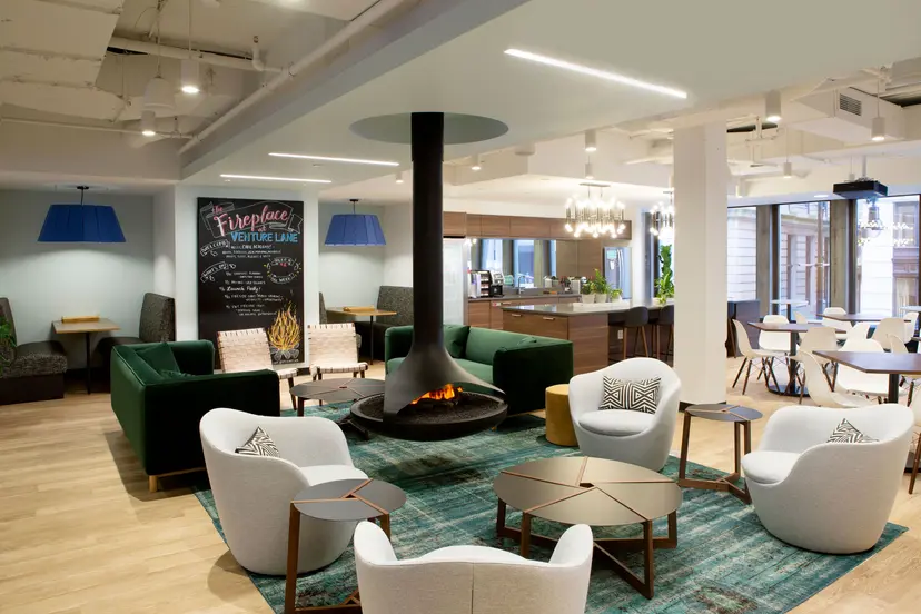 Modern coworking lounge with fireplace, seating area, and collaborative workspace amenities