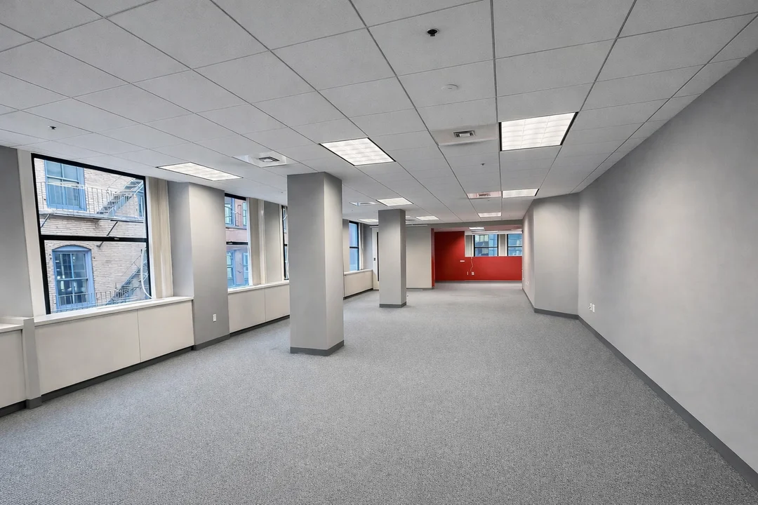 Open-plan commercial office space with natural light, flexible layout, and city-facing windows.